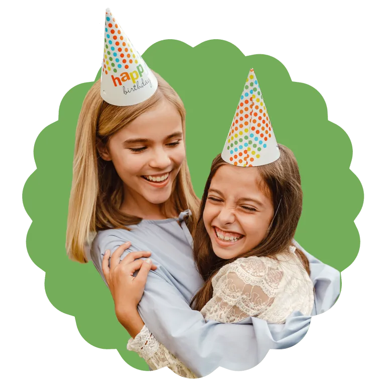 Stylized image of two girls hugging and smiling, wearing birthday hats